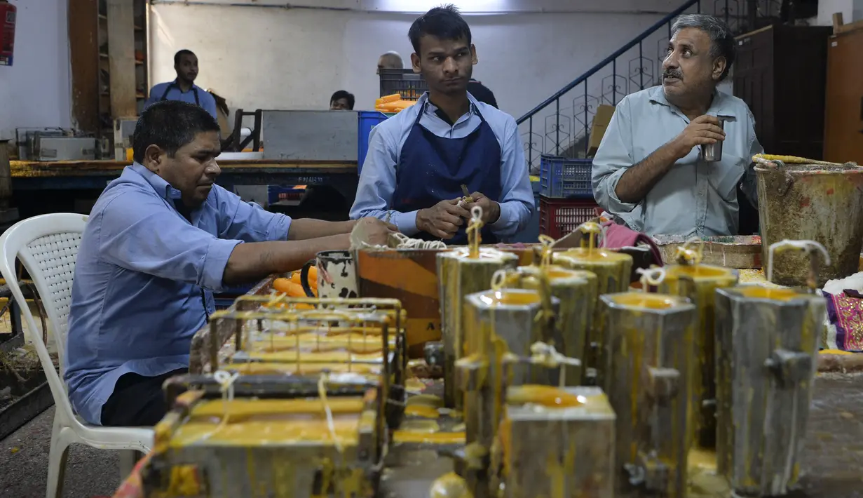 Para pekerja tunanetra membuat lilin di bengkel Blind School Relief Association, New Delhi, India, Rabu (16/10/2019). Perkumpulan tersebut menjual lilin, lampu minyak, dan produk kertas yang dibuat oleh para pekerja tunanetra jelang Festival Diwali atau Festival Cahaya. (Sajjad HUSSAIN/AFP)