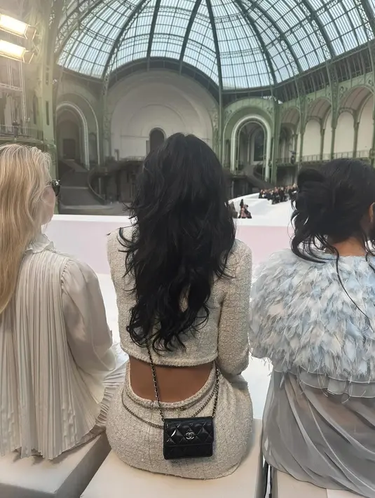 Untuk aksesori, Kylie menambahkan sentuhan kontemporer dengan sabuk rantai mutiara dan emas khas Chanel yang dililitkan di pinggangnya. Ia juga mengenakan tumpukan gelang emas dan berlian, serta sebuah anklet rantai emas dengan logo Chanel yang menggantung manis di atas slingback heels hitamnya. Detail ini memberikan kesan edgy namun tetap elegan, selaras dengan karakter mode Jenner yang selalu berani bereksperimen.  [IG: @kyliejenner].
