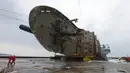 Petugas melintas didepan bangkai kapal Sewol yang berhasil diangkat di pulau barat daya Jindo, Korea Selatan (26/3). Kapal ini sebelumnya tenggelam hampir tiga tahun di kedalaman 44 meter. (HANDOUT / SOUTH KOREAN MARITIME MINISTRY / AFP)