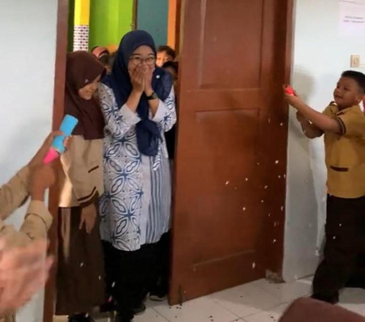 Saat masuk ke kelas, anak-anak pun mulai menembakkan confeti yang sejak tadi mereka pegang. Ibu guru kaget dan menunjukkan raut wajah bahagianya.&nbsp;