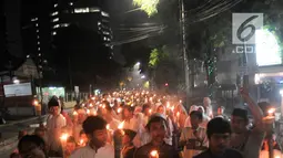Warga membawa obor saat pawai Tahun Baru Islam 1440 H di kawasan Menteng, Jakarta, Senin (10/9). Pawai obor yang diiringi musik bernuansa Islam merupakan tradisi umat muslim di Indonesia menyambut Tahun Baru 1 Muharram. (Merdeka.com/Iqbal S Nugroho)