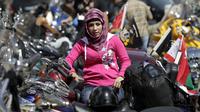 Ilustrasi wanita duduk di sepeda motor. (arabianbusiness.com)