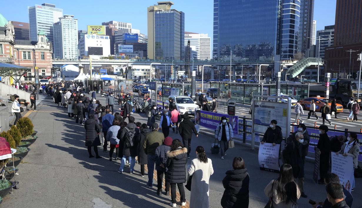 Orang-orang antre untuk menunggu tes covid-19 di tempat pengujian darurat di Seoul, Korea Selatan, Rabu (8/12/2021). Untuk pertama kalinya, Korea Selatan (Korsel) melaporkan lebih dari 7.000 kasus Corona dalam 24 jam terakhir. (AP Photo/Ahn Young-joon)