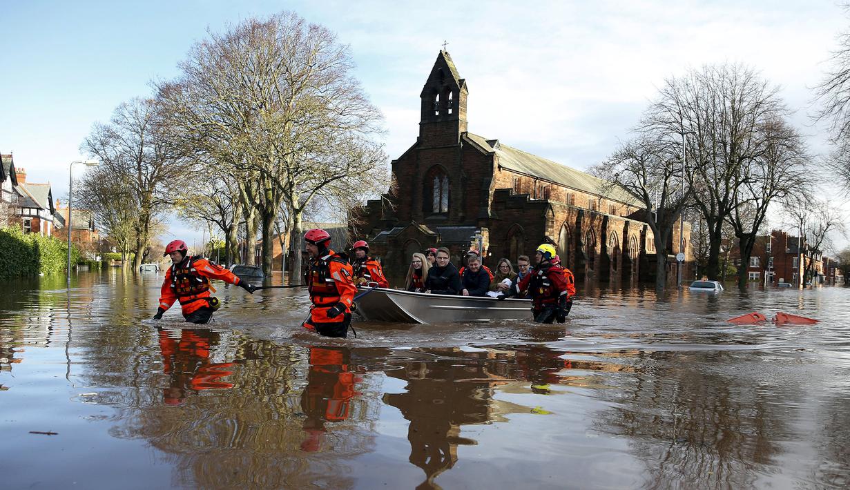 Petugas mengevakuasi warga menggunakan perahu karet di Carlisle, Inggris, Minggu (6/12). Puluhan ribu rumah tidak punya listrik karena Badai Desmond yang menyebabkan banjir di Inggris utara dan sebagian wilayah Skotlandia. (REUTERS/Phil Noble)