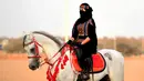 Perempuan Arab berpose saat menunggangi kuda dalam Festival Souk Okaz 2019 di Kota Taif, Arab Saudi, Rabu (7/8/2019). Perempuan penunggang kuda dari berbagai negara Arab ambil bagian dalam Festival Souq Okaz 2019. (AMER HILABI/AFP)