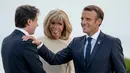 Presiden Prancis Emmanuel Macron (kanan) dan istrinya Brigitte Macron (tengah) menyambut kedatangan pemimpin sementara Italia Giuseppe Conte di KTT G7, Biarritz, Prancis, Sabtu (24/8/2019). (AP Photo/Andrew Harnik)