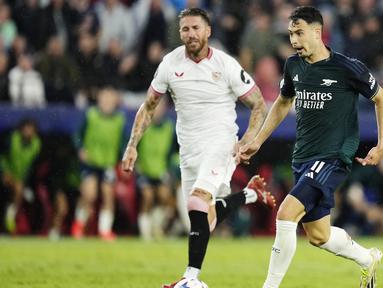 Pemain Sevilla, Sergio Ramos, berusaha mengejar pemain Arsenal, Gabriel Martinelli, pada laga Liga Champions di Stadion Ramon Sanchez Pizjuan, Rabu (25/10/2023). Sevilla tumbang 1-2 dari sang tamu. (AP Photo/Jose Breton)