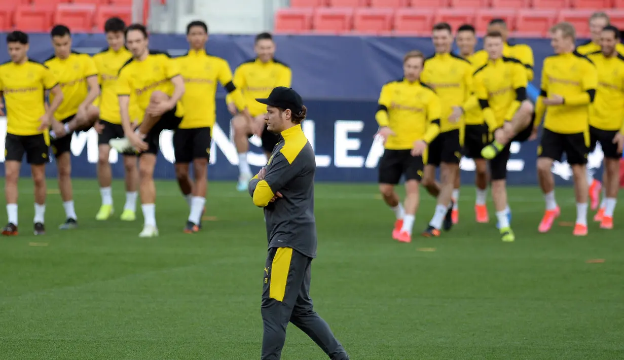 Pelatih Borussia Dortmund, Edin Terzic melihat pemainnya berlatih selama sesi latihan tim di stadion Ramon Sanchez Pizjuan di Seville (16/2/2021). Los Palanganas maupun Die Borussen sendiri terakhir kali bertemu pada musim 2009-2010 di ajang Liga Europa. (AFP/Cristina Quicler)