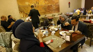 Sejumlah kafe di Irak mulai ramai dikunjungi saat waktu sahur oleh sejumlah warga, Irak, Kamis (9/7/2015). Setelah hampir 10 tahun tak boleh keluar malam, kini warga Irak bisa sahur bersama di Kafe. (Reuters Thaier Al-Sudani)