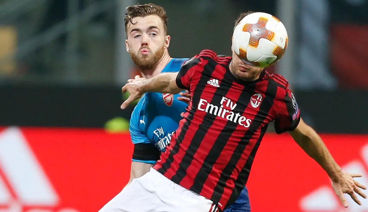 Pemain Arsenal Calum Chambers berebut bola dengan pemain AC Milan Giacomo Bonaventura saat pertandingan Liga Europa leg pertama di stadion San Siro Milan, Italia (8/3). (AP Photo / Antonio Calanni)