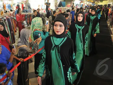 Sejumlah model berjalan di atas catwalk memperagakan busana muslim rancangan Itang Yunasz bertajuk Puspa Ragam Andalas di Pusat Grosir Blok B Tanah Abang, Jakarta, Kamis (30/4/2015). (Liputan6.com/Herman Zakharia)