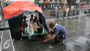 Seketika tetesan air hujan turun, tanda pertunjukan boneka kayu Muchtar harus terhenti, Jakarta, Kamis (17/12/2015). Dengan perlahan Muchtar menutup panggung boneka kayunya dengan sebuah terpal. (Liputan6.com/Yoppy Renato)