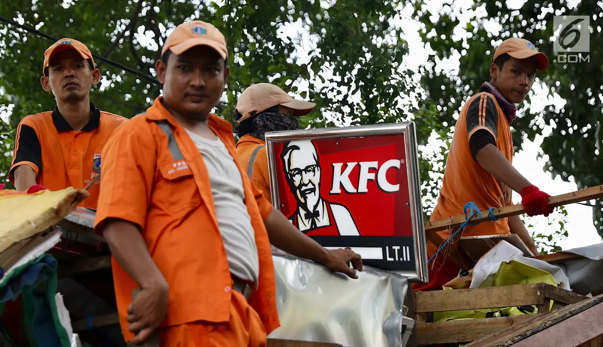 Pasukan Oranye mengangkut bekas bongkaran yang dilakukan Satpol PP saat melakukan penertiban di kawasan pusat perbelanjaan Pasar Baru, Jakarta, Rabu (21/2). (Liputan6.com/Immanuel Antonius)