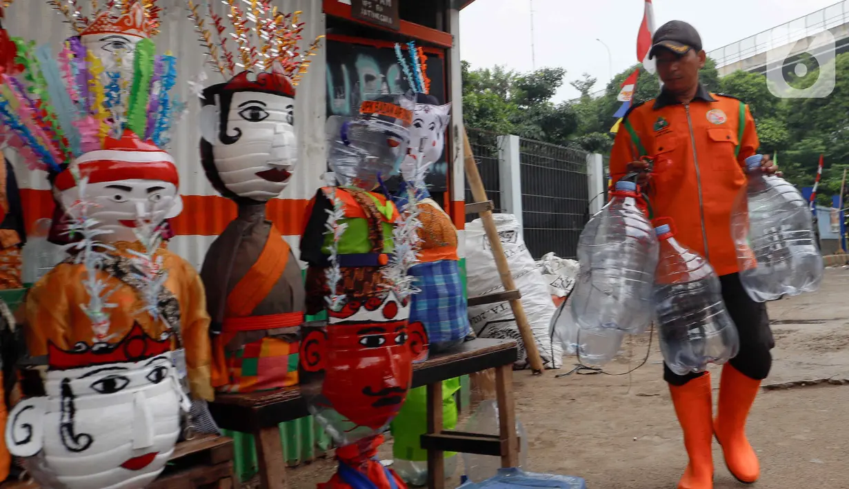 Petugas Unit Penanganan Sampah (UPS) Badan Air (BA) Dinas Lingkungan Hidup DKI Jakarta Kecamatan Jatinegara membuat ondel-ondel mini dari galon air minum bekas di Jakarta, Selasa (25/6/2024). (Liputan6.com/Herman Zakharia)