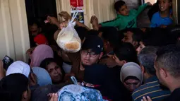 Ini adalah rutinitas yang sangat melelahkan – menunggu berjam-jam untuk mendapatkan roti, mencoba mencari air, menenangkan anak-anak saat terjadi pengeboman. (AP Photo/Fatima Shbair, File)