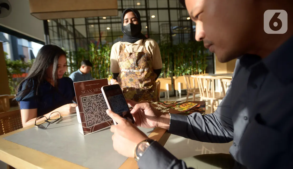 Pengunjung memindai barcode saat memesan makanan di Synthesis Huis, Jakarta, Selasa (22/11/2022). Synthesis Huis menjadi destinasi wisata kuliner sambil nonton bareng Piala Dunia 2022. (merdeka.com/Imam Buhori)