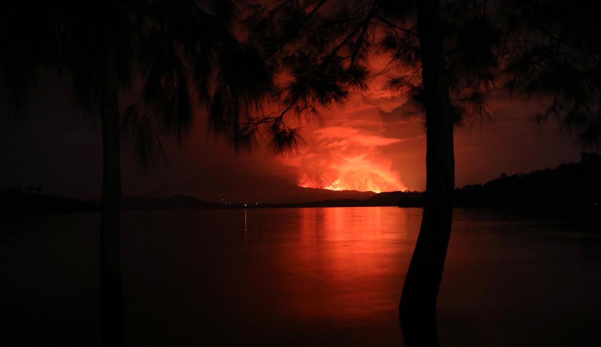 Pemandangan pada 22 Mei 2021 dari Pulau Tchegera di luar Goma di danau Kivu di sebelah timur Republik Demokratik Kongo menunjukkan semburan api dari gunung berapi Nyiragongo. Ahli vulkanologi yang berbasis di Goma, Dario Tedesco, mengatakan retakan baru sedang terbuka di Nyiragongo. (Alex Miles/AFP)