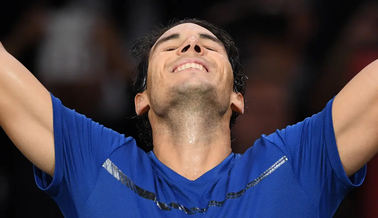 Petenis Spanyol, Rafael Nadal merayakan kemenangannya atas petenis Korea Selatan, Hyeon Chung pada babak kedua Paris Masters di Paris, Rabu (1/11). Nadal sukses mengunci peringkat satu dunia pada akhir tahun 2017. (CHRISTOPHE ARCHAMBAULT / AFP)