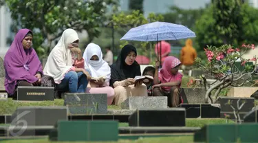 Sejumlah warga melakukan ziarah di salah satu makam di Tempat Pemakaman Umum (TPU) Karet Bivak, Jakarta, Rabu (6/7). Setelah melakukan salat Idul Fitri, sebagian warga melakukan ziarah ke makam kerabat mereka. (Liputan6.com/Yoppy Renato)