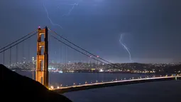 Suasana jembatan Golden Gate saat terjadi sambaran petir, San Francisco, California, AS (11/9). Petir merupakan Gejala alam yang biasanya muncul pada musim hujan di saat langit memunculkan kilatan cahaya sesaat yang menyilaukan. (AFP Photo/Josh Edelson)
