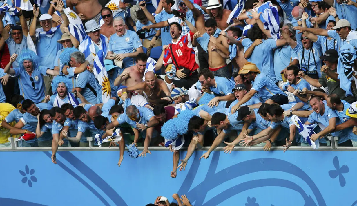 Suporter Timnas Uruguay menyambut gembira gol yang diciptakan Diego Godin ke gawang Italia di laga penutup penyisihan Piala Dunia Grup D di Stadion das Dunas, Natal, Brasil, (24/6/2014). (REUTERS/Carlos Barria)