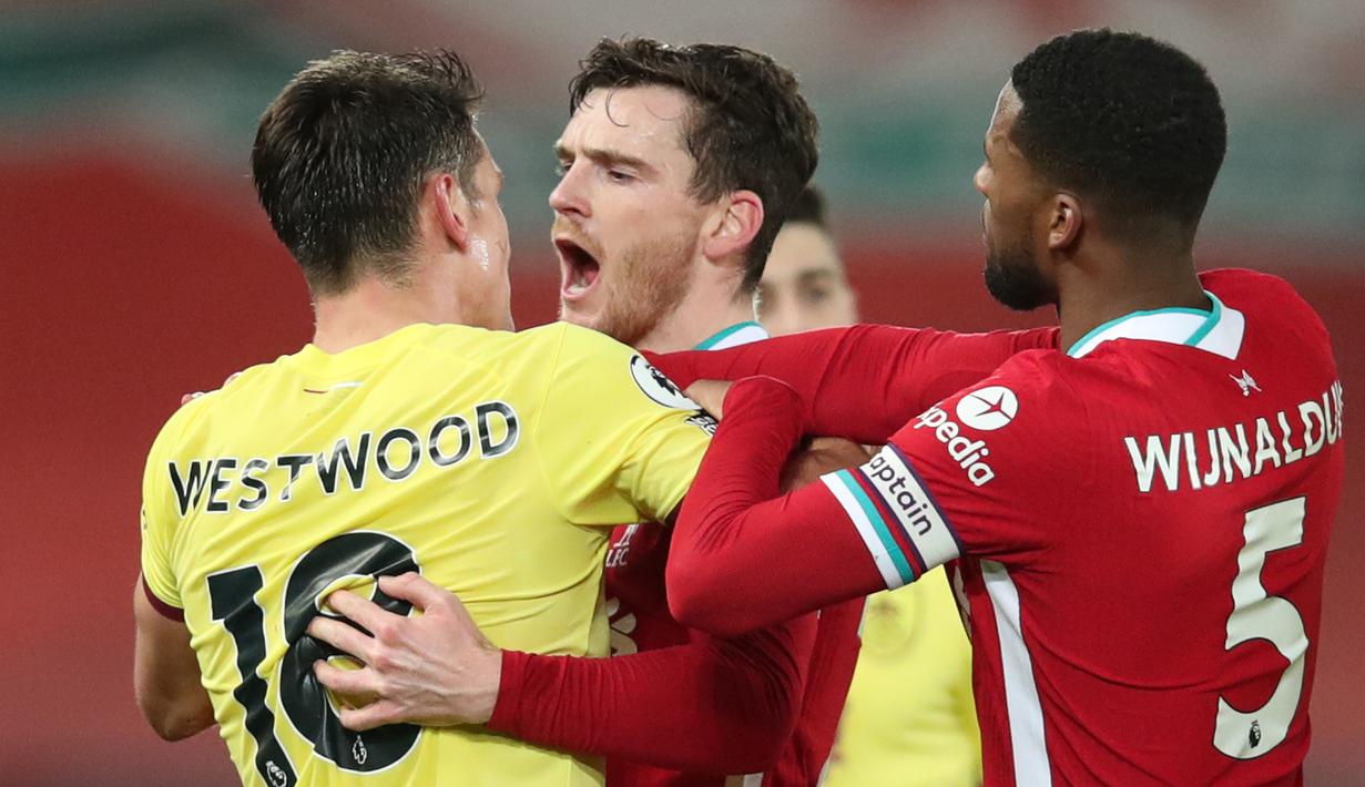 Bek Liverpool, Andrew Robertson (tengah) terlibat pertikaian dengan gelandang Burnley, Ashley Westwood dalam laga lanjutan Liga Inggris 2020/21 di Anfield Stadium, Liverpool, Kamis (21/1/2021). Liverpool kalah 0-1 dari Burnley. (AFP/Clive Brunskill/Pool)