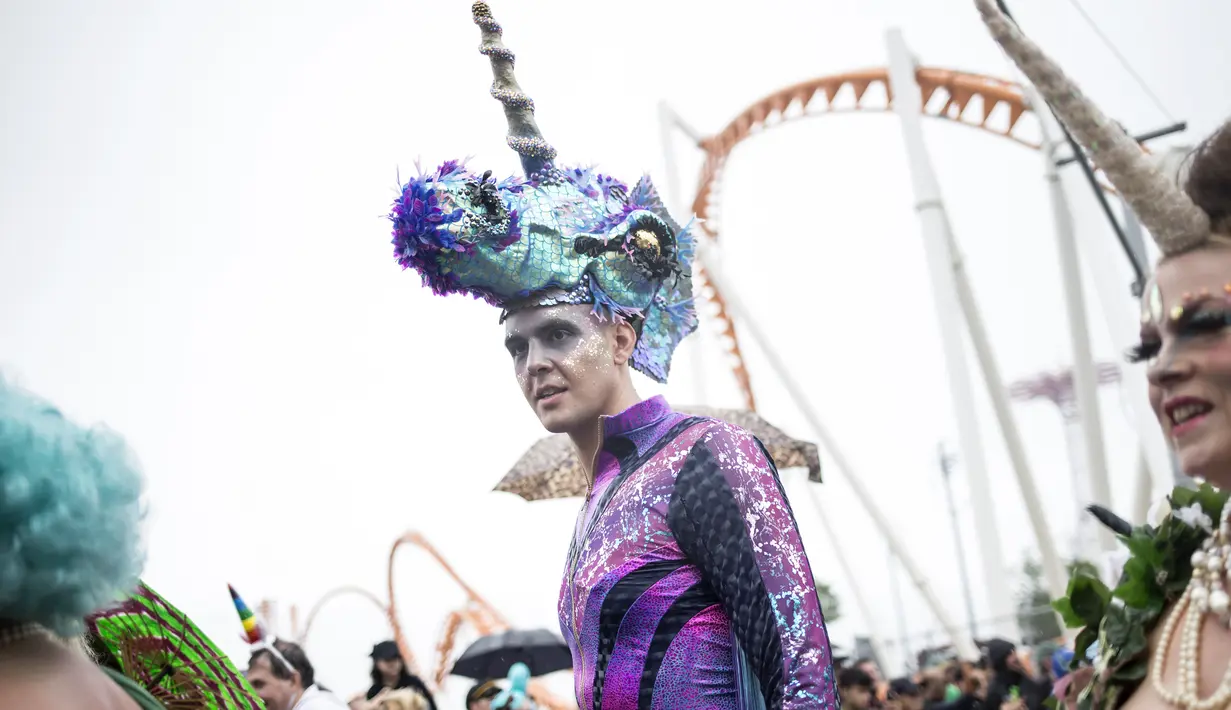 Seorang pria mengenakan kostum dan tanduk menyerupai kuda laut saat Parade Mermaid 2017 di Coney Island, New York City (17/6). Parade ini diikuti lebih dari 3000 orang peserta yang mengenakan busana bertema Mermaid. (Alex Wroblewski/Getty Images/AFP)