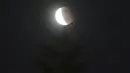 Bulan purnama muncul di atas pohon saat gerhana bulan total terjadi pada hari mendung di Taipei, Taiwan, Rabu (26/5/2021). Gerhana bulan total yang bertepatan dengan Supermoon untuk pertama kalinya dalam dua tahun. (AP Photo/Chiang Ying-ying)
