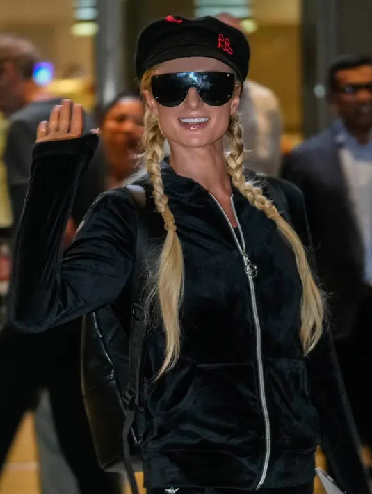 <p>Selebritas Amerika Serikat Paris Hilton melambai kepada fotografer saat tiba di Bandara Internasional Chhatrapati Shivaji, Mumbai, India, 19 Oktober 2022. Wanita 41 tahun itu mengenakan pakaian olahraga hitam beludru dengan hiasan kepala. (AP Photo/Rafiq Maqbool)</p>