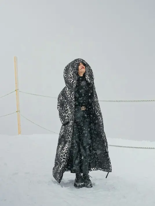 Main salju, Fuji tetap terlihat menawan. Fuji memadukan semua outfitnya yang serba hitam. Ia mengenakan turtleneck dipadu celana panjang, belt branded, dan jaket bulu panjang bercorak kulit harimau yang semuanya berwarna hitam. [Foto: Instagram/fuji_an]