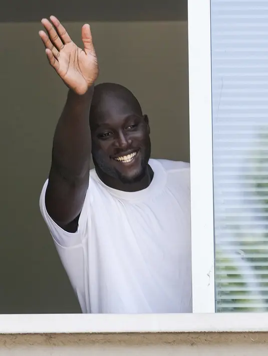 Penyerang asal Belgia, Romelu Lukaku melambaikan tangan ke pendukung Inter Milan dari jendela markas Komite Olimpiade Italia di Milan, Italia, Rabu (29/6/2022).Gaji Romelu Lukaku juga dipotong sebesar 35 persen untuk memuluskan peminjamannya. (AP Photo/Luca Bruno)