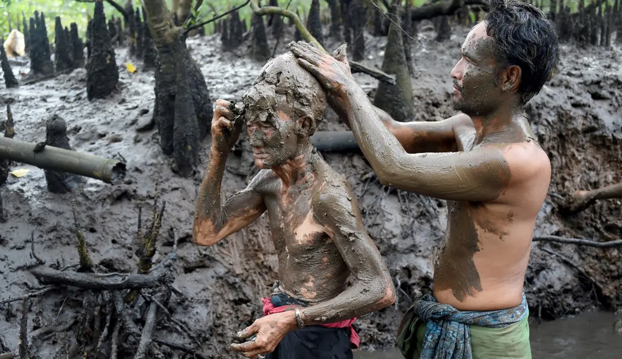 Orang-orang mengambil bagian dalam tradisi mandi lumpur yang dikenal sebagai Mebuug-buugan di Desa Kedonganan, Bali, 4 Maret 2022. Mebuug-buugan diadakan sehari setelah Nyepi yang bertujuan untuk menetralkan sifat buruk. (SONY TUMBELAKA/AFP)