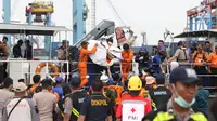 Petugas menurunkan sejumlah barang temuan yang diduga milik penumpang pesawat Lion Air JT 610 di Pelabuhan JICT 2, Jakarta, Selasa (30/10). Sejumlah barang ditemukan petugas gabungan dalam operasi pencarian. (Liputan6.com/Helmi Fithriansyah)