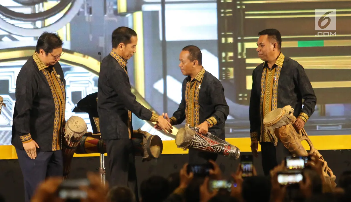 Presiden Joko Widodo (kedua kiri) bersalaman dengan Ketum Himpunan Pengusaha Muda Indonesia (HIPMI), Bahlil Lahadalia (kedua kanan) usai memainkan alat musik khas Papua selama Musyawarah Nasional XVI HIPMI di Hotel Sultan, Jakarta, Senin (16/9/2019). (Liputan6.com/Angga Yuniar)