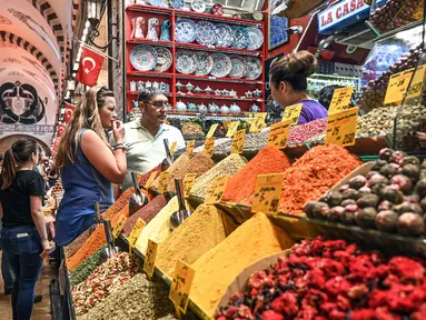 Orang-orang berbelanja di pasar rempah-rempah atau Spice Bazaar yang bersejarah di distrik Eminonu di Istanbul, (13/7/2019). Spice Bazaar adalah salah satu bazaar terbesar di kota tersebut. (AFP Photo/Ozam Kose)