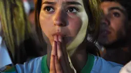 Harap-harap cemas menyelimuti hati seluruh pendukung Aljazair termasuk fans cantik yang satu ini, Senin (30/6/2014) (AFP PHOTO/FAROUK BATICHE)