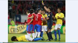 Wasit Ecuador Roddy Zambrano memberikan kartu kuning kepada pemain Chile Marcelo Diaz (kiri) pada laga kualifikasi Piala Dunia 2018 di Santiago, Chile, Kamis (08/10/2015). Chile menang 2-0. (AFP Photo/Claudio Reyes)