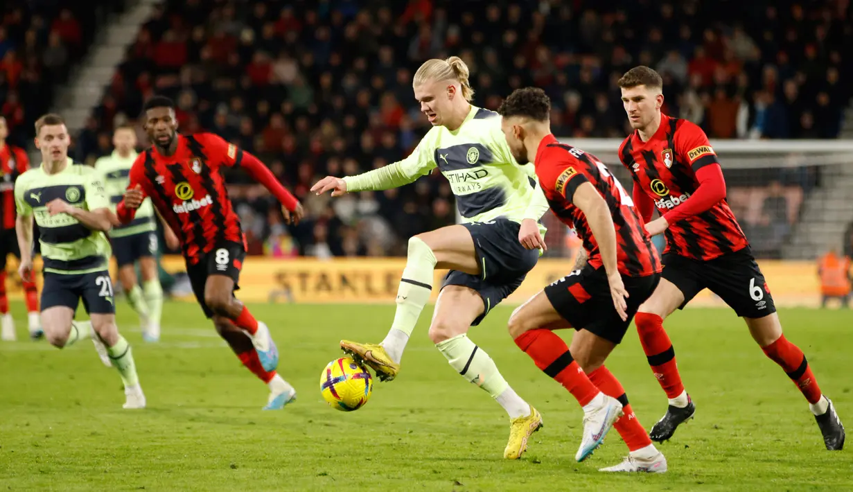 Pemain Manchester City Erling Haaland (tengah) berduel memperebutkan bola dengan pemain Bournemouth Ryan Fredericks pada pertandingan sepak bola Liga Inggris di Vitality Stadium, Bournemouth, Inggris, 25 Februari 2023. Manchester City mengalahkan Bournemouth dengan skor 4-1. (AP Photo/David Cliff)