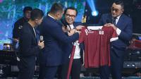 Indosiar menggelar Konser Gila Bola di Studio 5 Indosiar Jakarta Barat, pada Kamis (20/10/2022) malam. Tampak Ari Lasso menerima kostum Emtek yang dibuat khusus untuk Piala Dunia 2022. (Bagaskara Lazuardi/Bola.com)