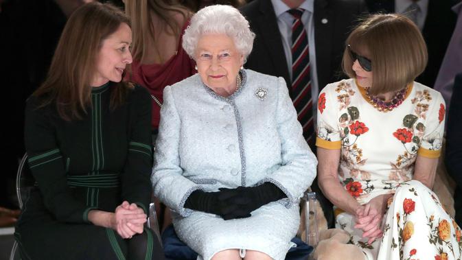 Ratu Elizabeth II berbincang dengan chief executive British Fashion Council, Caroline Rush dan Ratu Fashion, Anna Wintour (kanan) ketika menonton pagelaran London Fashion Week 2018, Selasa (20/2). (Yui Mok/Pool photo via AP)