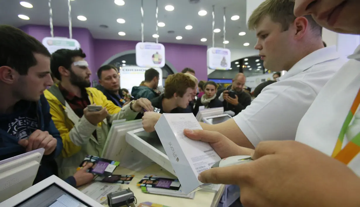 Salah satu kasir memindai iPhone 6 di sebuah toko ponsel di Moskow, Jumat, (26/9/2014). (REUTERS/Maxim Shemetov)