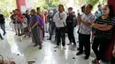 Orang-orang berdiri di tugu peringatan darurat untuk korban kerusuhan di depan Gerbang 13, Stadion Kanjuruhan, Malang, Selasa (4/10/2022). Polri menjatuhkan sanksi kepada 10 anggota polisi dan menyelidiki 18 orang lainnya buntut tragedi kerusuhan yang menewaskan 125 orang di Stadion Kanjuruhan. (AP Photo/Achmad Ibrahim)