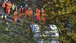 Petugas layanan darurat berkumpul di lokasi terbaliknya sebuah trem di sebuah terowongan di Croydon, London Selatan, Inggris, Rabu (9/11). Masinis trem telah diamankan dan tim penyelidik mulai mencari tahu penyebab kecelakaan. (REUTERS/Neil Hall)