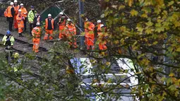 Petugas layanan darurat berkumpul di lokasi terbaliknya sebuah trem di sebuah terowongan di Croydon, London Selatan, Inggris, Rabu (9/11). Masinis trem telah diamankan dan tim penyelidik mulai mencari tahu penyebab kecelakaan. (REUTERS/Neil Hall)