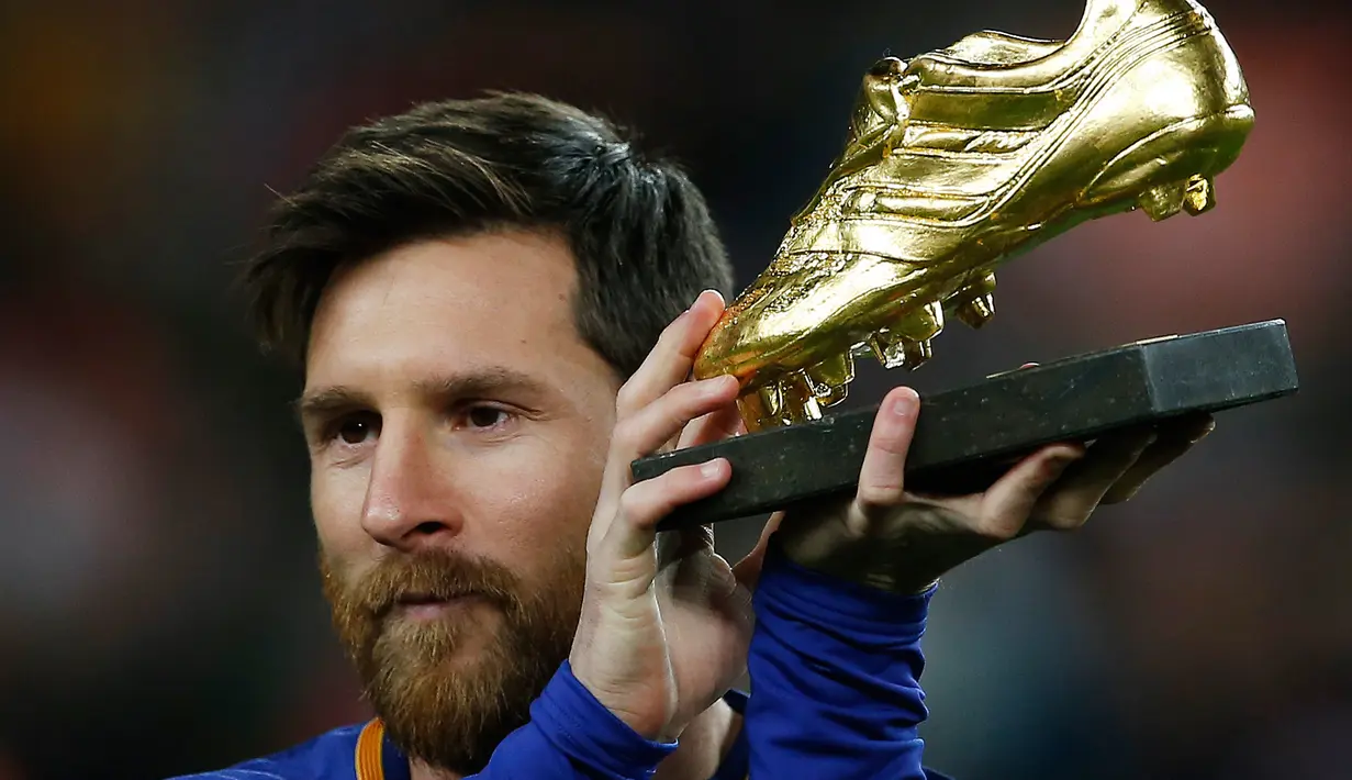 Pemain bintang Barcelona, Lionel Messi memamerkan Sepatu Emasnya sebelum pertandingan melawan Deportivo La Coruna dalam liga Spanyol di stadion Camp Nou di Barcelona (17/12). (AP Photo/Manu Fernandez)