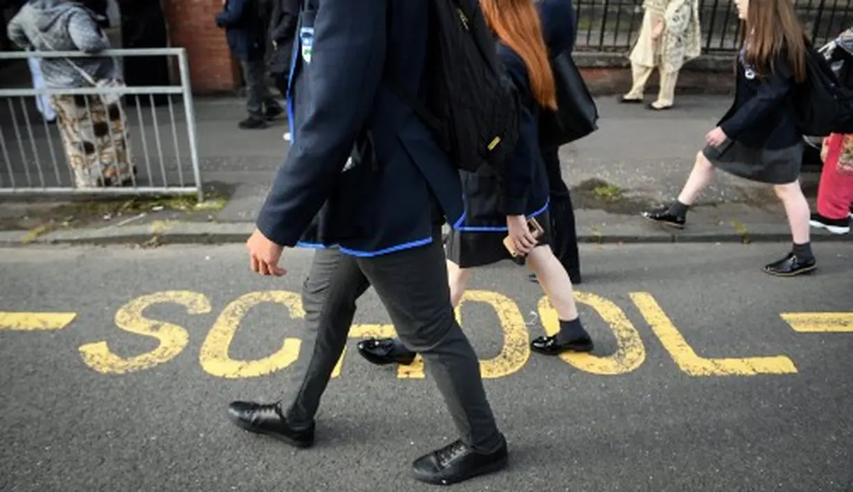 Aktivitas pelajar Holyrood Secondary School saat berangkat ke sekolah untuk pertama kalinya di Glasgow, Skotlandia (12/8/2020).  (AFP/ANDY BUCHANAN)