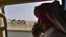 Pemilik mengikuti unta balapnya dari mobil pada Festival Unta Putra Mahkota di Kota Taif, Arab Saudi, Rabu (11/8/2021). Selain mempromosikan warisan balap unta Arab Saudi, festival ini juga berupaya untuk mendukung pariwisata dan pembangunan ekonomi. (Amer HILABI/AFP)
