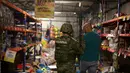 Polisi AL Meksiko mengamankan seorang pria yang melakukan penjarahan di sebuah toko di negara bagian Veracruz, Rabu (4/1). Penjarahan terjadi di sejumlah toko di Meksiko, seiring berlangsungnya unjuk rasa memprotes kenaikan harga BBM. (Ilse HUESCA/AFP)