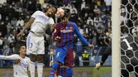 Bek Real Madrid, Eder Militao berebut bola udara dengan bek Barcelona, Gerard Pique pada pada semifinal Piala Super Spanyol di Stadion King Fahd di Riyadh, Arab Saudi, Kamis (13/1/2022). Real Madrid akan bertemu pemenang Atletico Madrid vs Athletic Bilbao di Final. (AP Photo/Hassan Ammar)