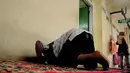 Seorang pedagang laki-laki tampak sholat persis di depan toilet umum di Pasar Blok G, Tanah Abang, Jakarta, (8/7/2014) (Liputan6.com/ Faizal Fanani)